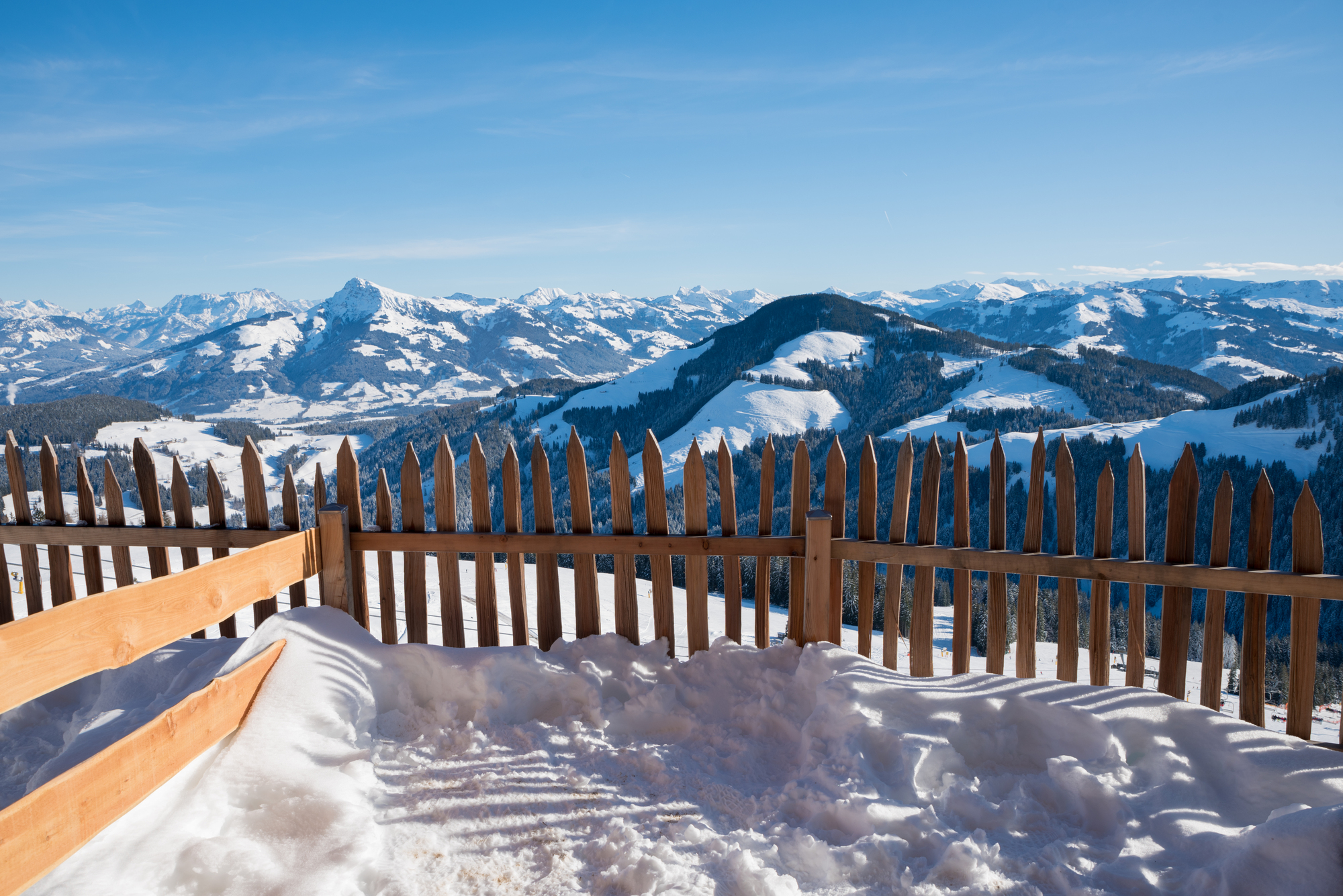 Wooden fence on a slope with snowy mountain view