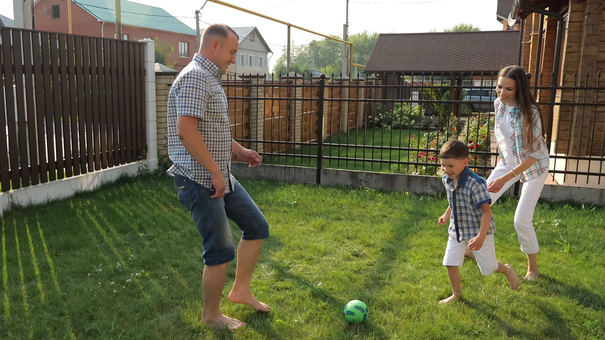 a family in the backyard with a modern fence